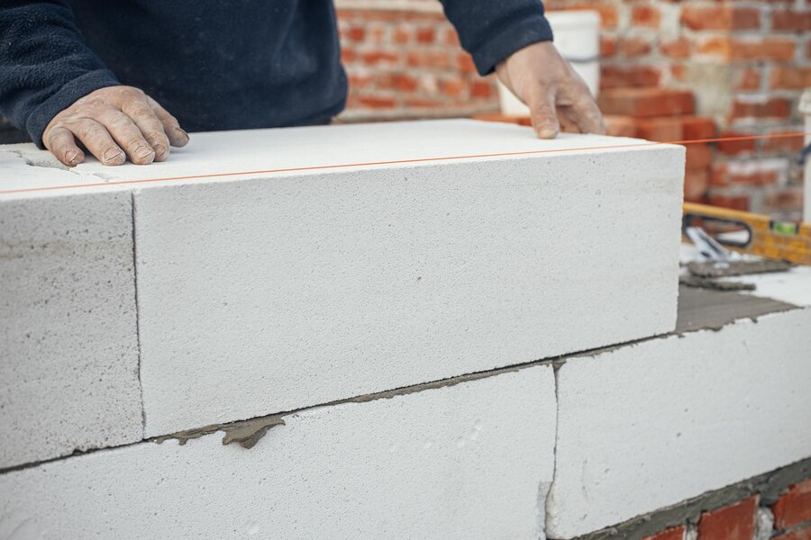 masonry worker laying autoclaved aerated concrete blocks builder installing white blocks close up 250813 24291